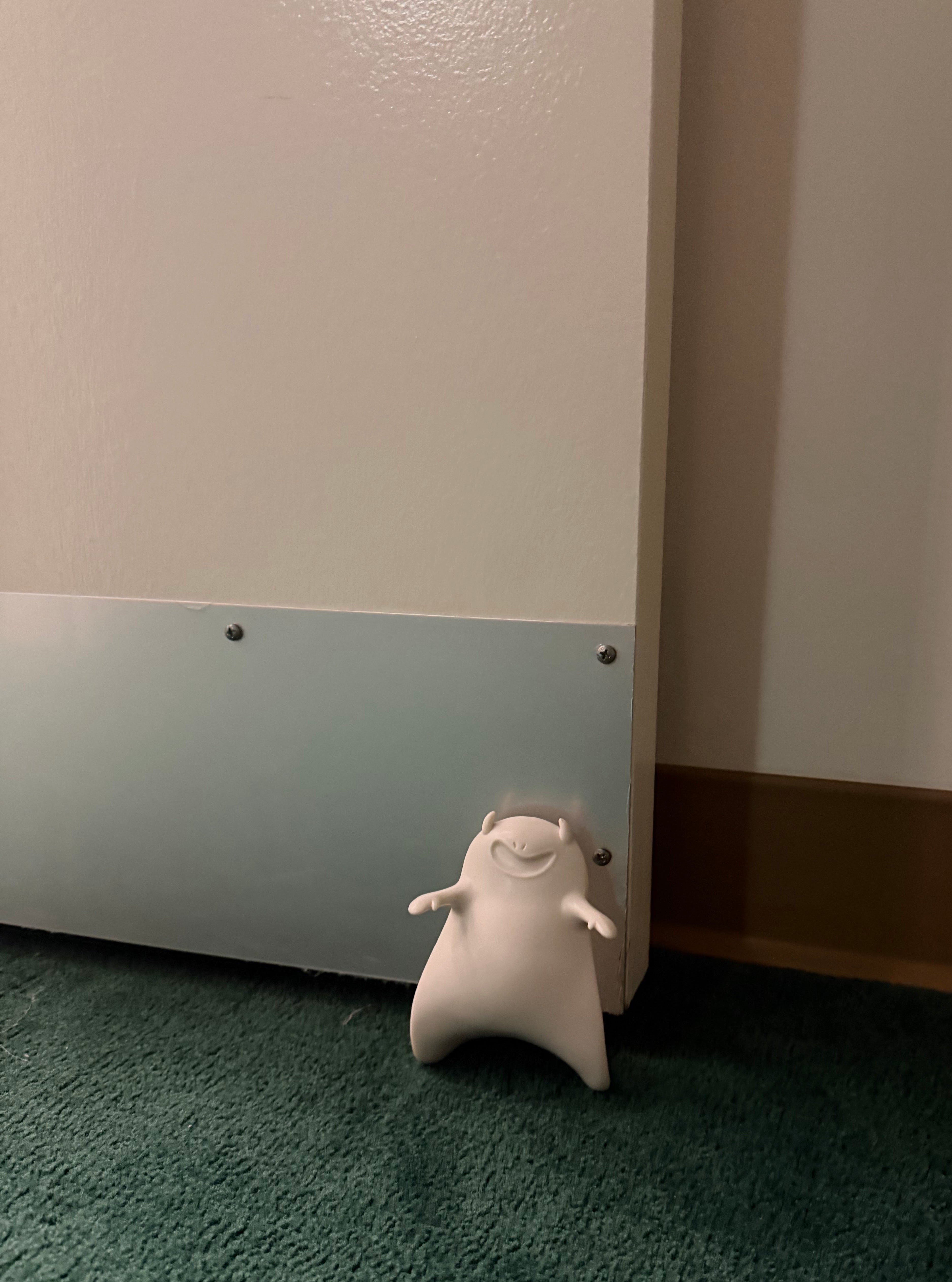 White Halloween Ghost Door Stopper holding door open - close up view